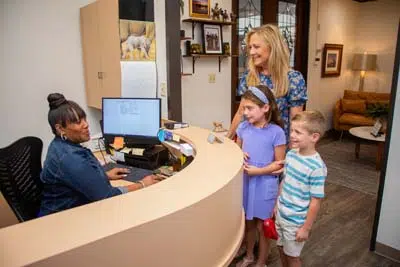 mom scheduling a dental appointment for her and her two kids at Mills Dental Group in Houston, TX