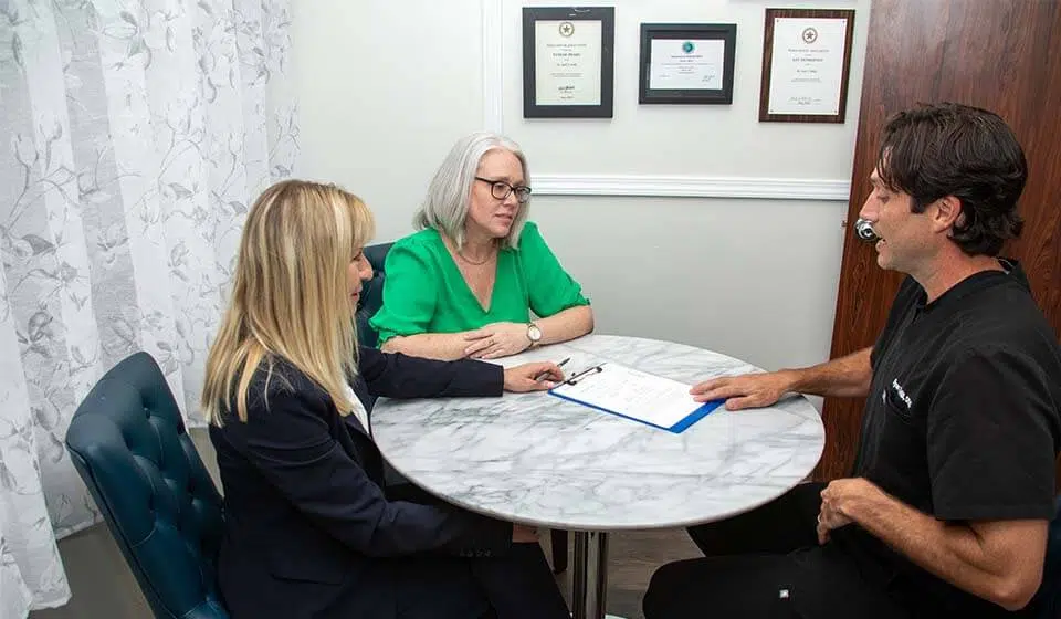 Dr. Ryan Hill discussing a treatment plan with patients at Mills Dental Group in Houston, TX