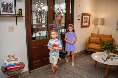 woman taking her two children to their dental appointment at Mills Dental Group in Houston, TX